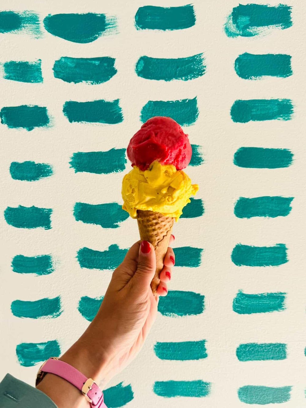 Cornet double sorbet framboise et mangue devant le mur turquoise Gaga Glaces